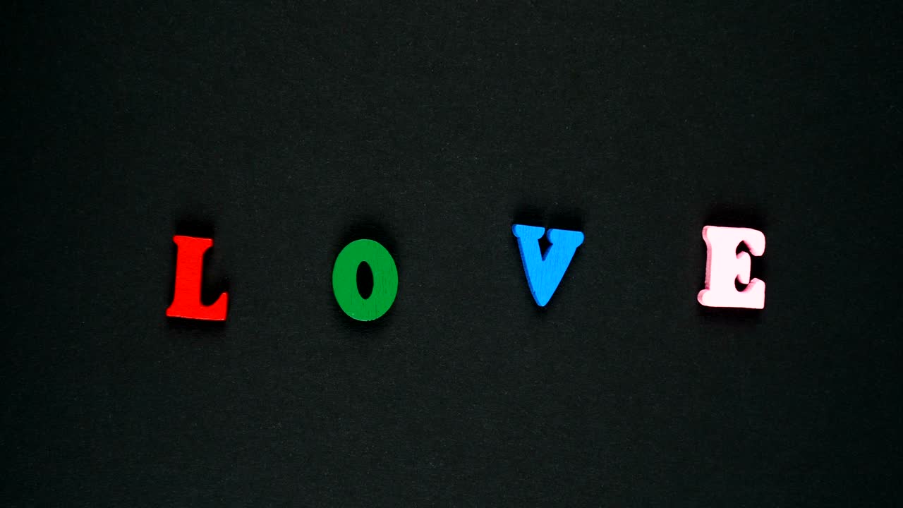 la palabra amor formada por letras de madera multicolores. palabras coloridas bucle. stop motion animación