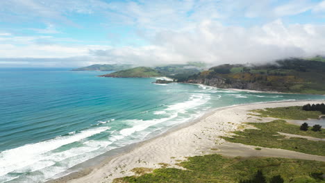 playa paraíso y montañas majestuosas en la isla sur de la costa pacífica, nueva zelanda, panorama aéreo