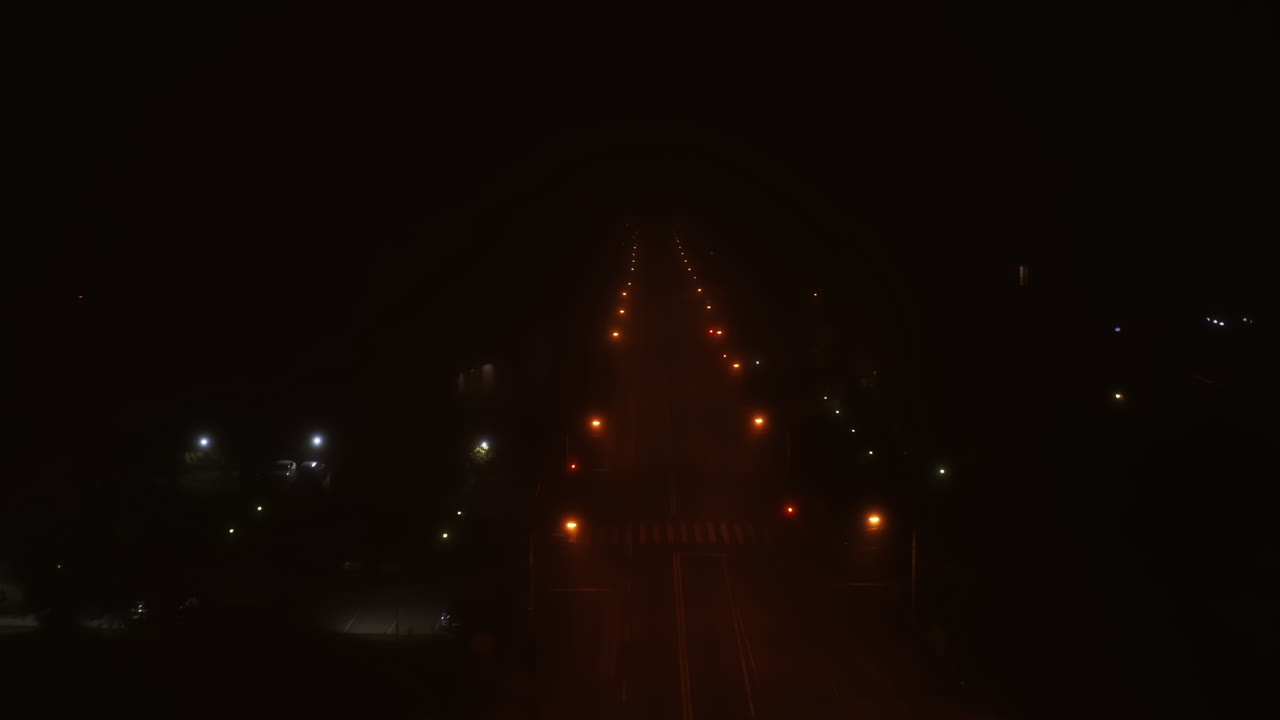 carretera con niebla aérea y luces de la calle por la noche con una carretera vacía en rumania, cluj-napoca