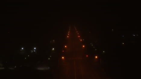 aerial foggy road and street lights at night with an empty road in romania, cluj-napoca