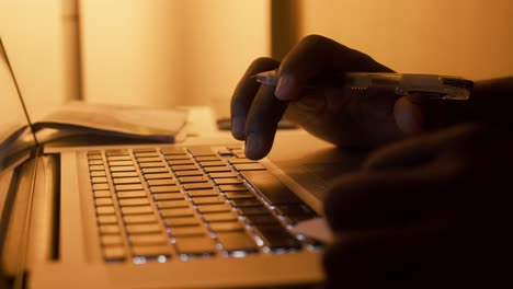 joven negro enfocado escribiendo usando una computadora portátil para trabajar en línea