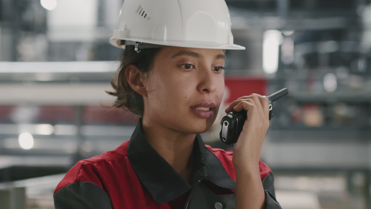 Appaltatrice donna in fabbrica con walkie-talkie