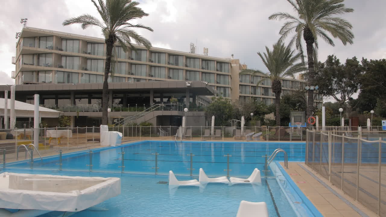 호텔의 대형 수영장, 겨울 동안 비활성, 모든 장비가 접혀 있고 덮여 있으며 슬로우 모션 돌리는 왼쪽