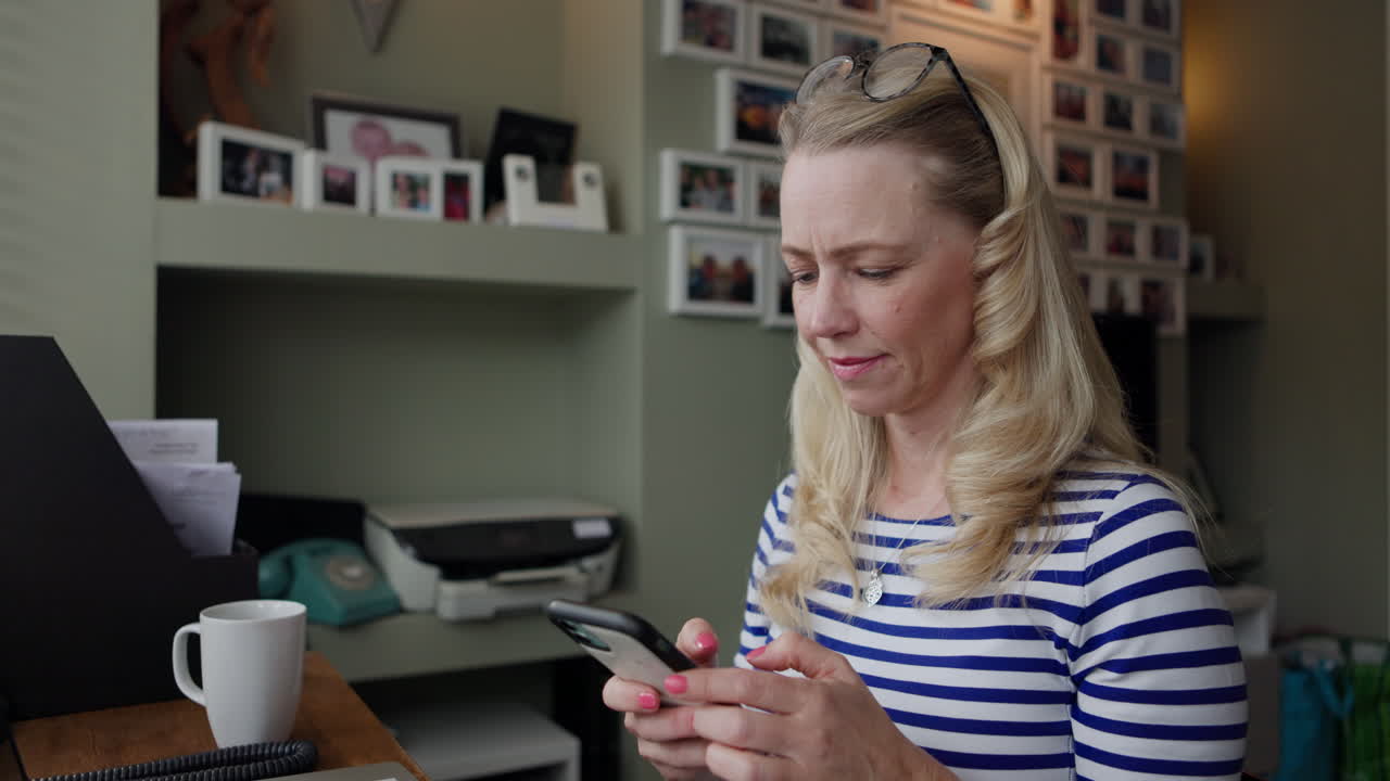 Woman using phone in home office