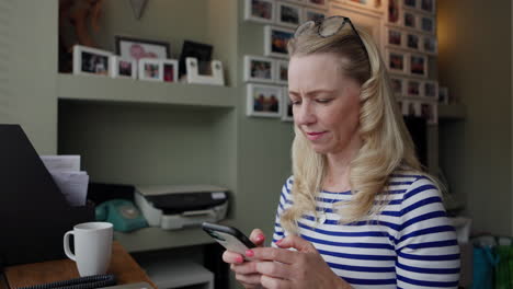 woman using phone in home office
