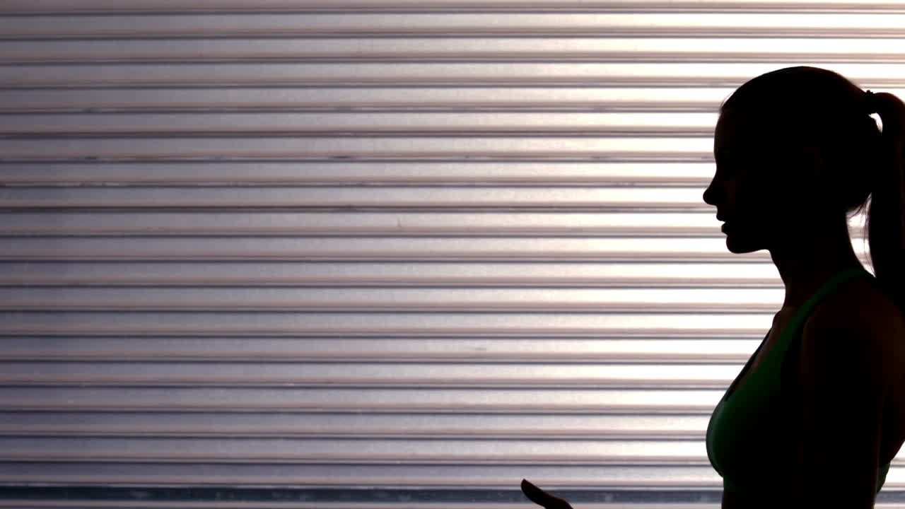 Side view of fit woman launching exercise ball 