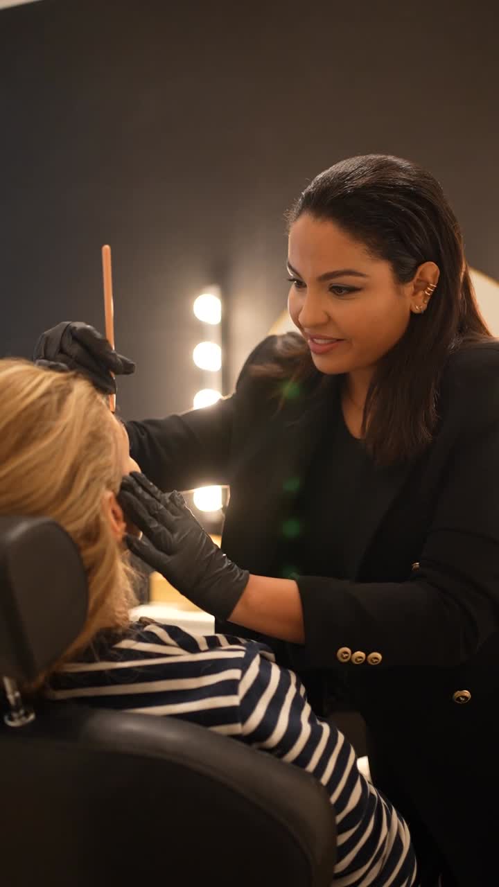Beautician working on client's eyebrows at a beauty salon