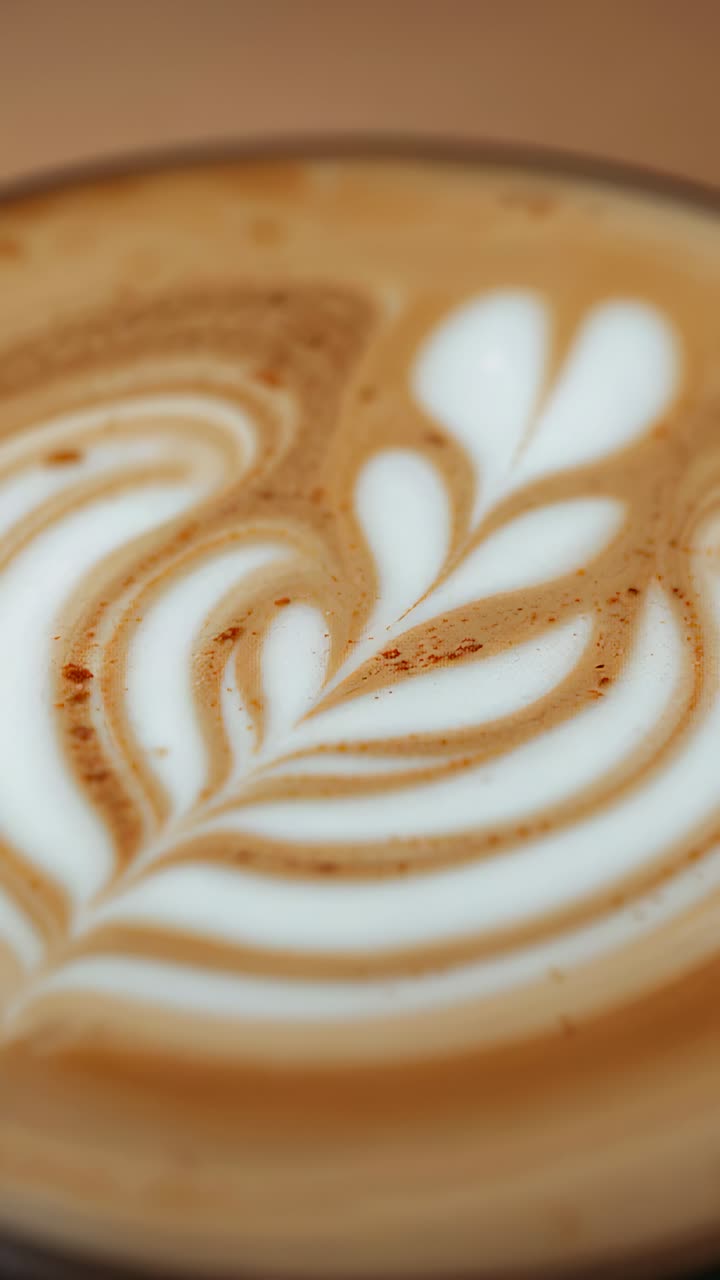 Vertical video: Camera tightening framing, revealing latte at counter, showing rosetta foam specks