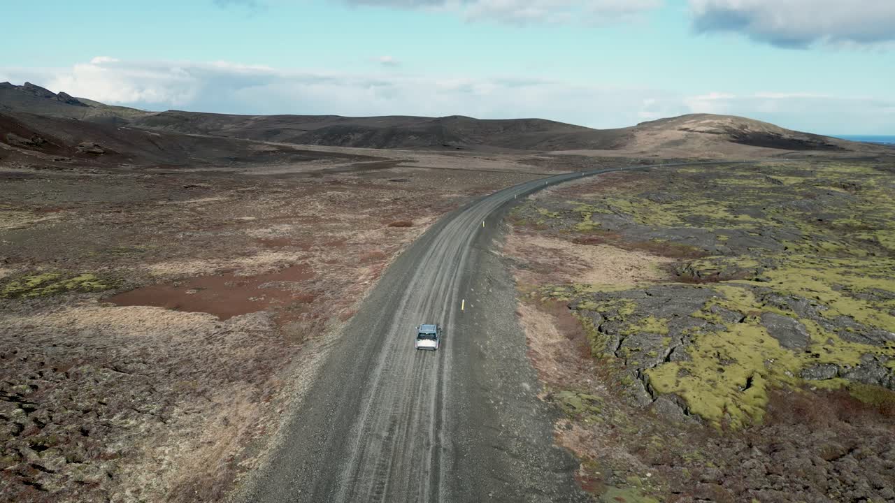 드론에서 볼 수 있는 아이슬란드 풍경의 아름다움을 목격하고, 화산 지형을 따라 휘어지는 자동차를 따라, 모험으로 거친 풍경을 정복합니다.