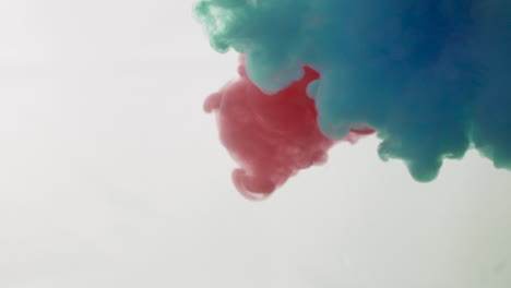 gotas de tinta de pintura de color rojo y azul claro en cámara lenta de agua 100 fps