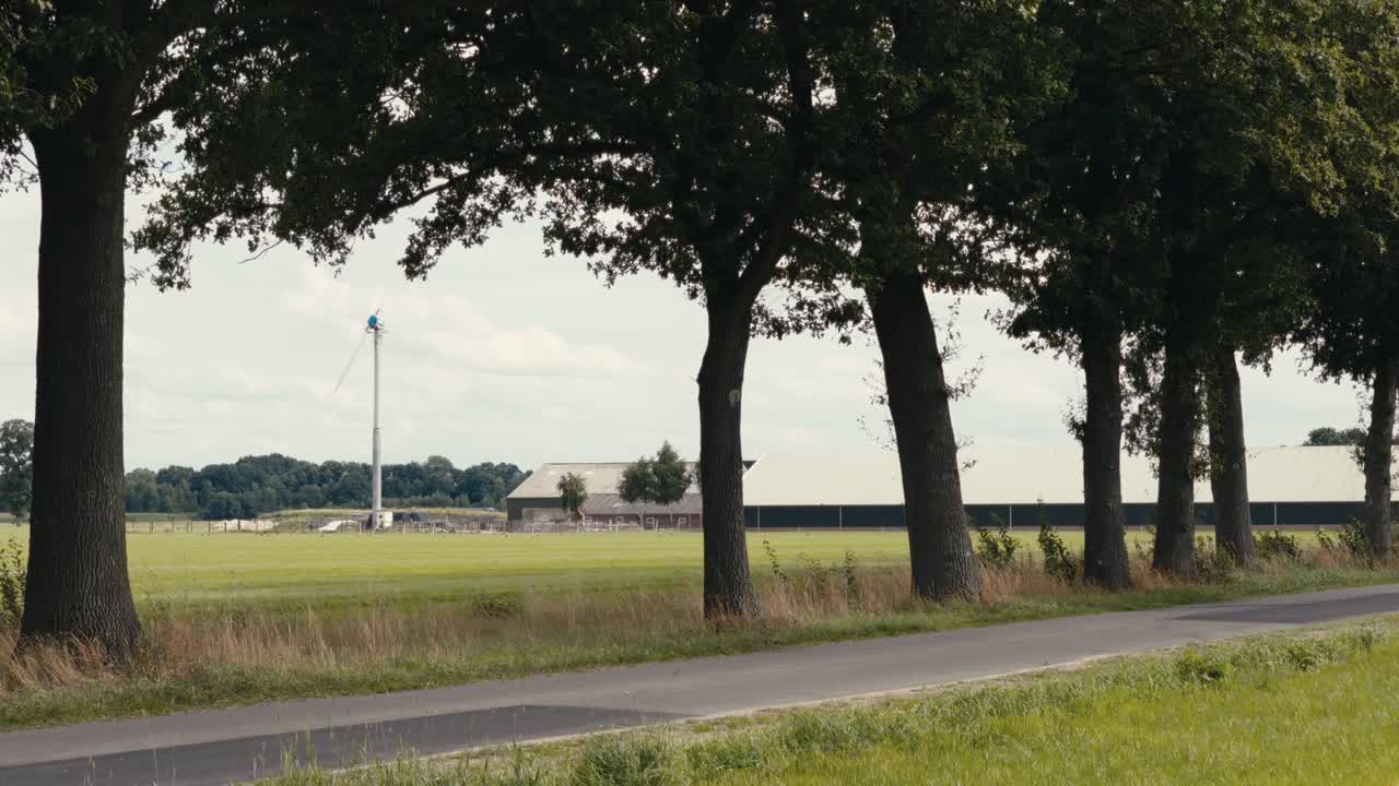 Drone shot of a large modern agricultural facility with barns and silos surrounded by lush farmland and rural roads