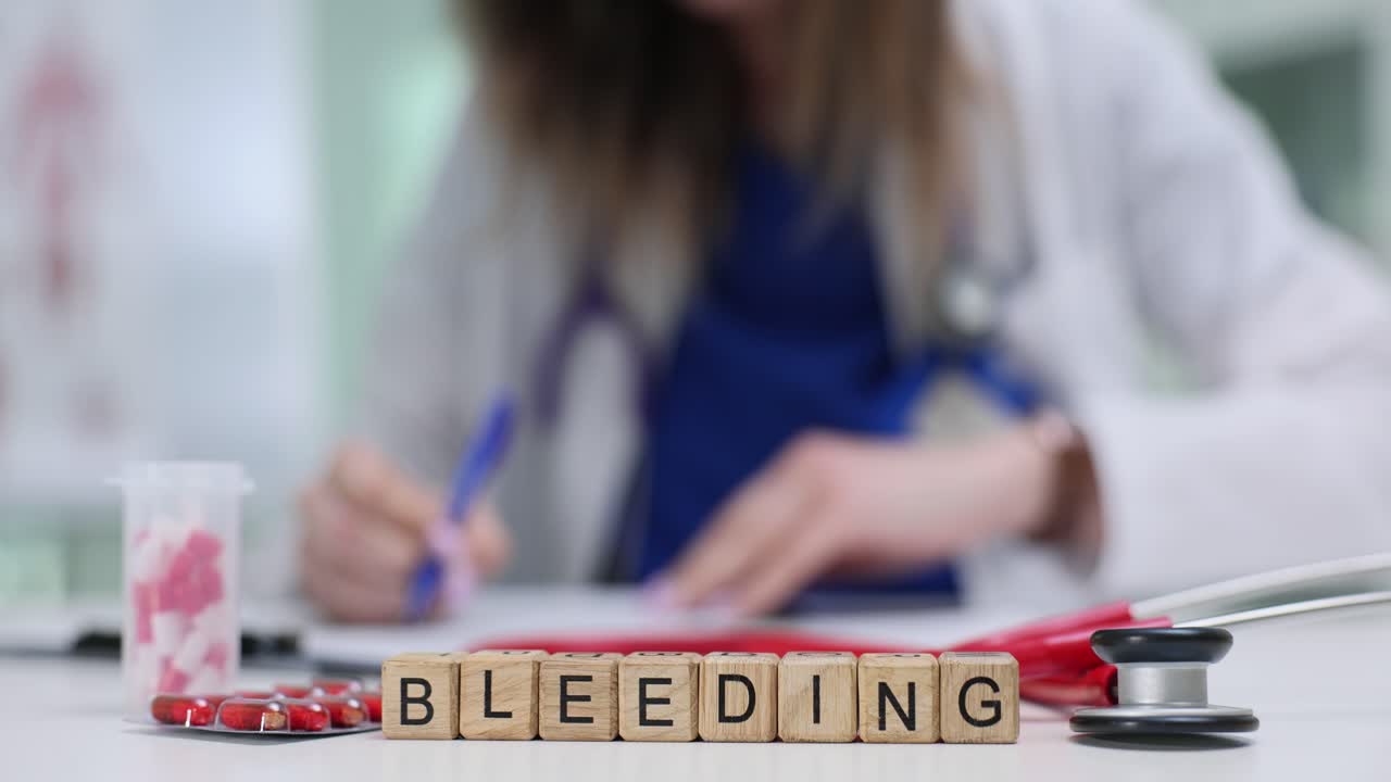 Wooden Blocks Spelling Bleeding on Doctor's Desk with Medical Supplies