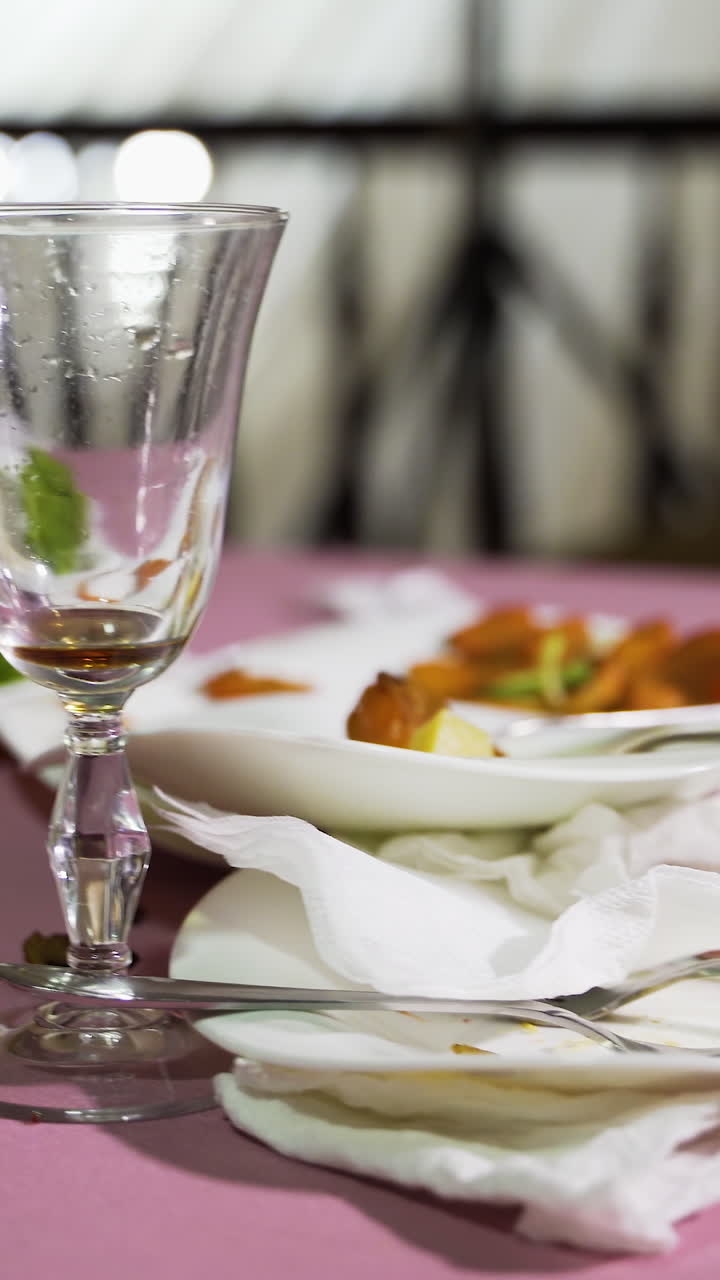 Remains of food in plates, crumbs on the table after lunch or dinner. Concept of the restaurant business. Vertical video