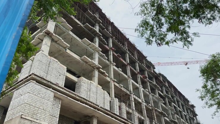 Vista de seguimiento en ángulo bajo de un edificio de hormigón armado en construcción con estructura visible
