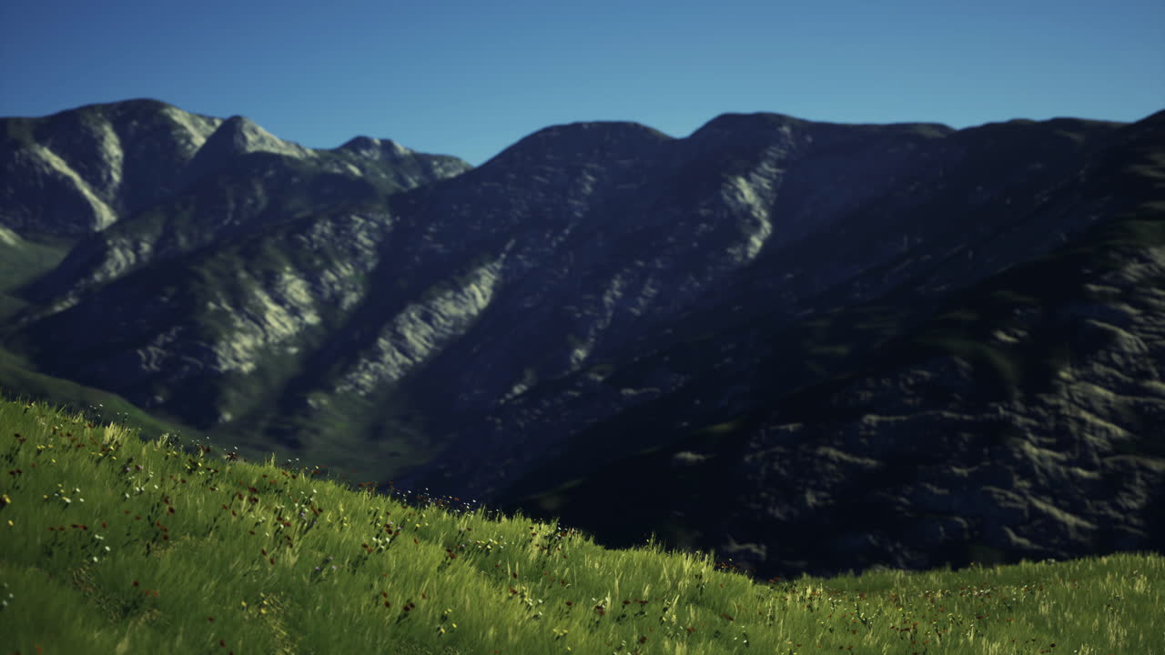 Mountains rise majestically under a clear blue sky during daylight hours