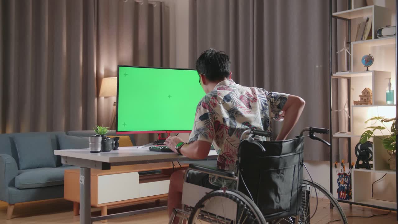 체어 에 앉은 아시아인 이 집 에서 카메라  에 있는 녹색 스크린 데스크 을 사용 하는 동안 허리 통증 을 겪고 있는 모습