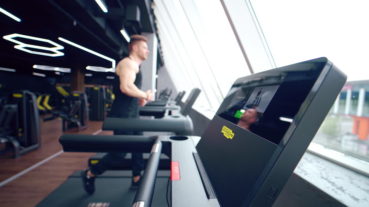 Fitness man training cardio exercise. Runner man training on treadmill machine in fitness center
