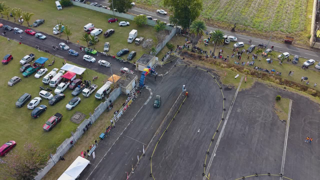 Aerial shot of a racing event area in Mauritius, surrounded by green fields and stadium grounds, captured by drone in UHD quality