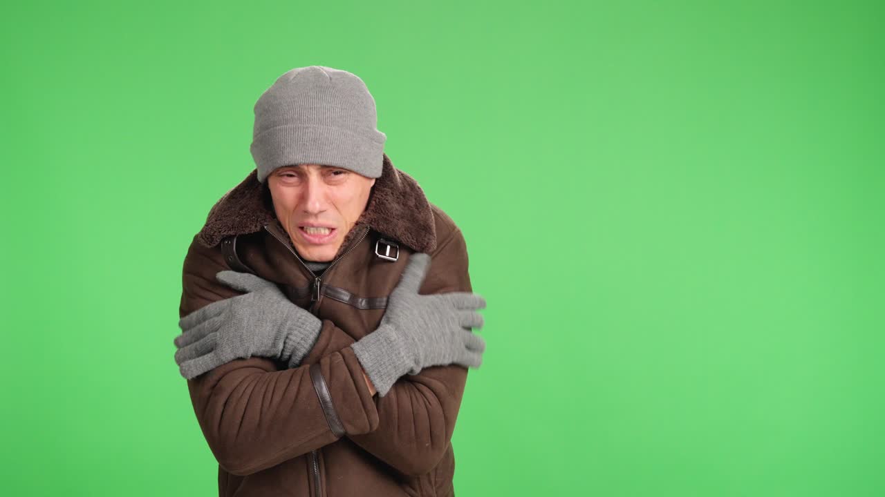 Man shivering and freezing on green screen background