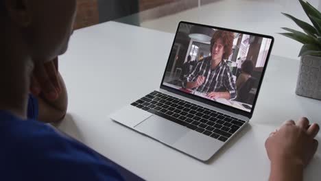 afroamericano hablando en video llamada en computadora portátil con un estudiante universitario caucásico en casa
