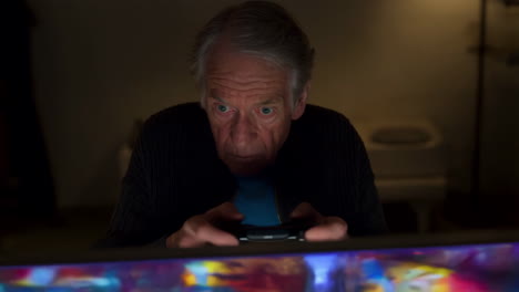 senior man playing video games at night