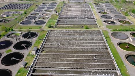 aerial shot of a wastewater treatment plant and distant skyline. big city waste processing concept