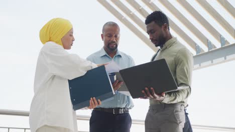 happy diverse business people discussing work and using laptop at office, slow motion