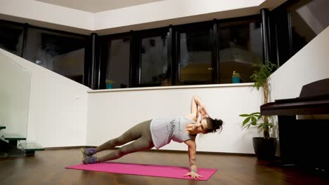 posicionándose hacia el lado izquierdo, una mujer levanta las caderas con los codos para estabilizarla mientras hace planking para mejorar sus músculos abdominales