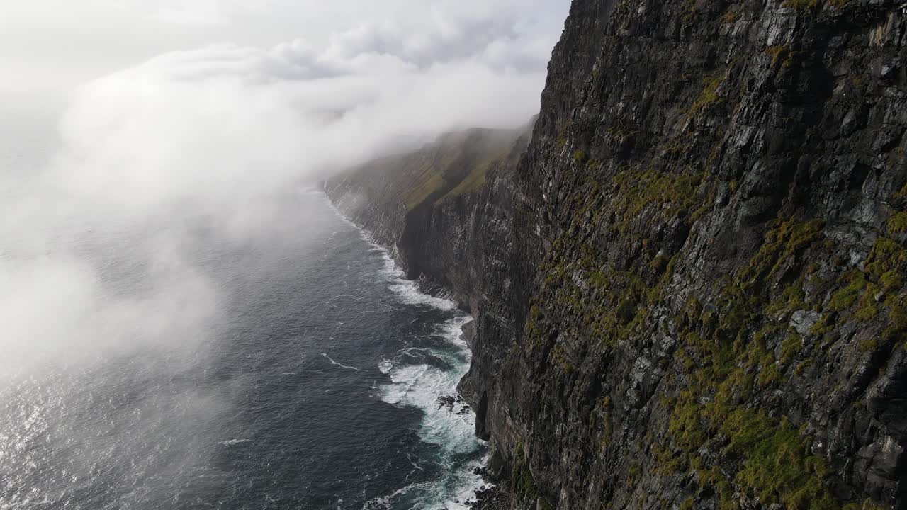 imágenes de drones de acantilados muy altos cerca del dedo de la bruja en sandavagur en la isla vagar en las islas feroe