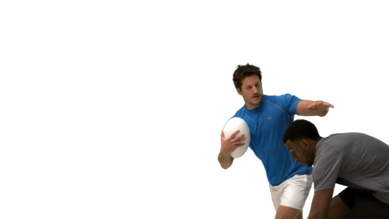 Serious rugby players tackling for ball