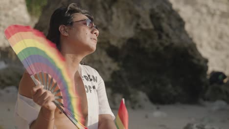 man at the beach with rainbow fan