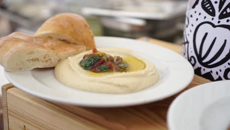 SLOWMO---Plate-of-hummus-on-white-plate-at-food-festival---Close-Up