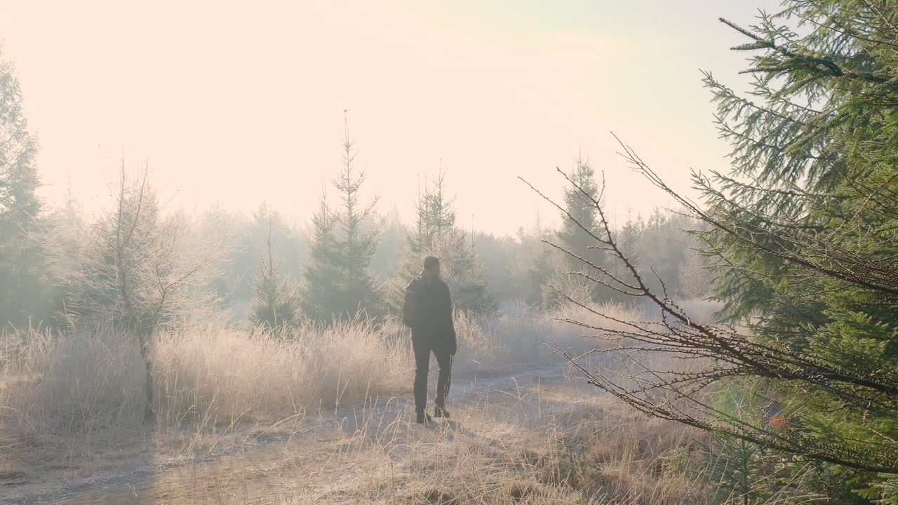 Man Hiking in a Foggy Winter Forest