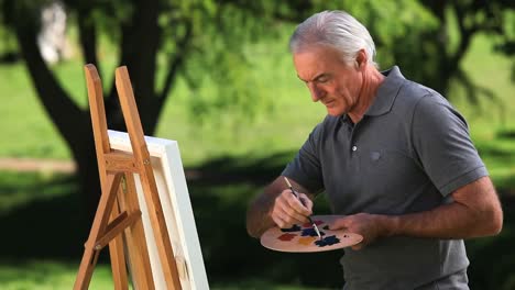 old man painting a canvas