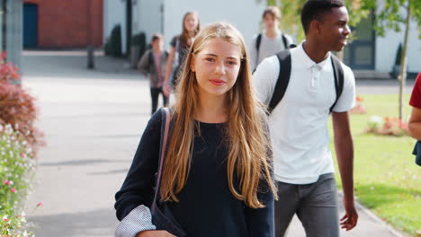 retrato de una estudiante adolescente caminando por el campus universitario