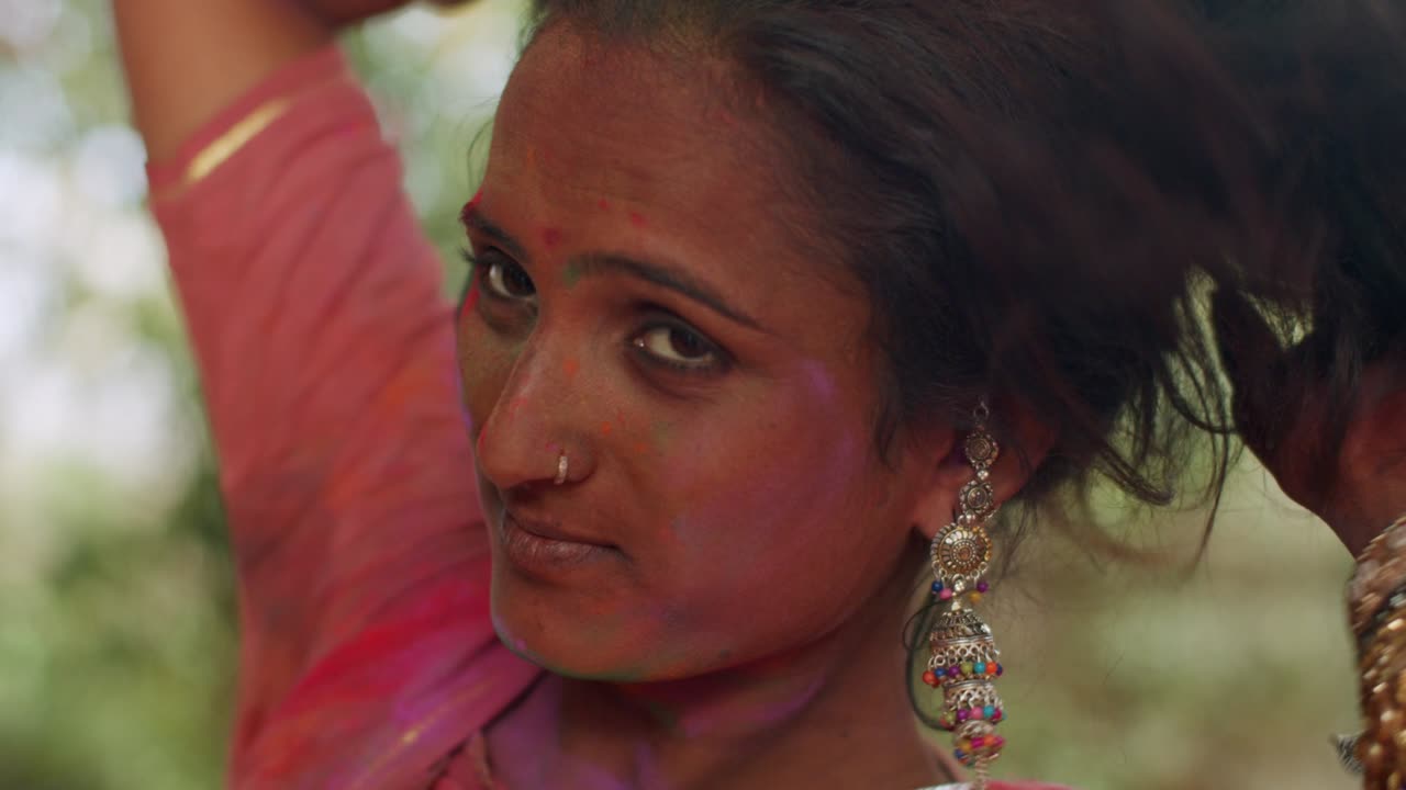 mujeres indias de primer plano de la cara manchada con colores brillantes de holi