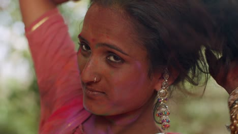 indian women close-up of face smeared with bright holi colors