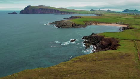 Toma-Panorámica-De-4k-De-Sybill-Point-Y-Acantilados-De-La-Península-De-Dingle-Con-Montañas-En-La-Distancia-En-Kerry,-Irlanda