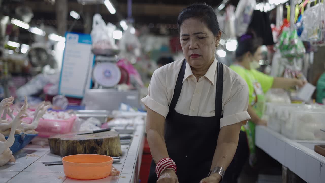 Woman preparing chicken in a market