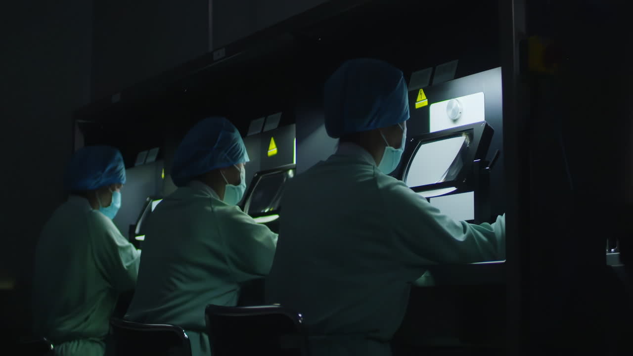 Medical research scientists in lab coat conducting biological experiment on Cell culture essay in biological cabinet on in cleanroom environmental facility laboratory, advanced equipment for Analysis