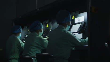medical research scientists in lab coat conducting biological experiment on cell culture essay in biological cabinet on in cleanroom environmental facility laboratory, advanced equipment for analysis