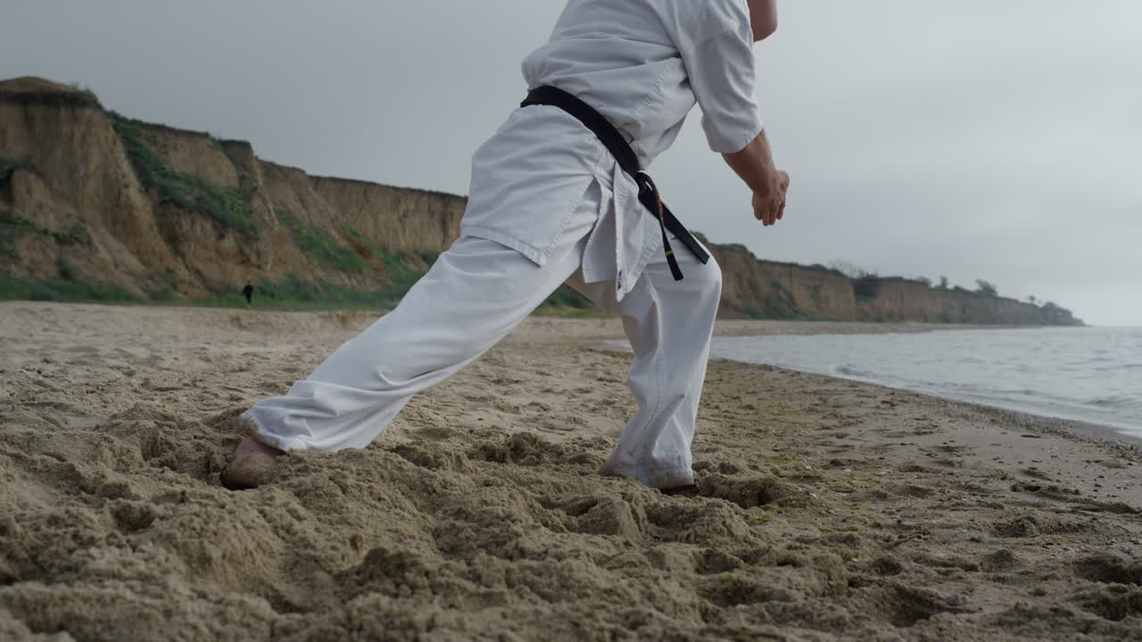 las piernas del hombre caminando haciendo ejercicio de karate de cerca. hombre entrenando habilidades de combate.