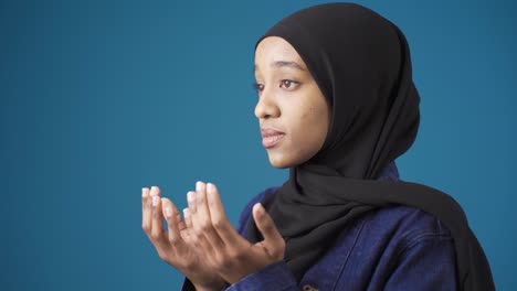 innocent and beautiful muslim african woman in hijab is praying. faithful african woman.