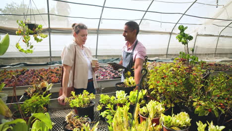 diverse gardeners tending to plants in greenhouse, discussing care techniques and growth