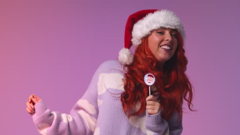 Studio-Shot-Of-Young-Gen-Z-Woman-Wearing-Christmas-Santa-Hat-Dancing-Against-Pink-Background-At-Party