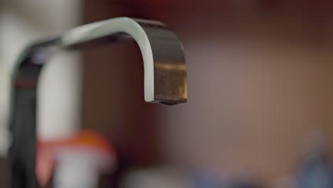 Tap-dripping-water-in-the-kitchen-with-soft-lighting