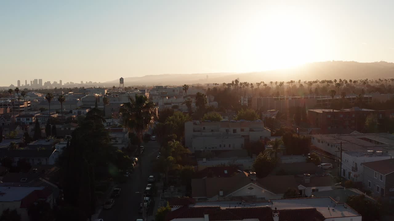 Ripresa aerea ascendente dell'espansione urbana di Hollywood al tramonto