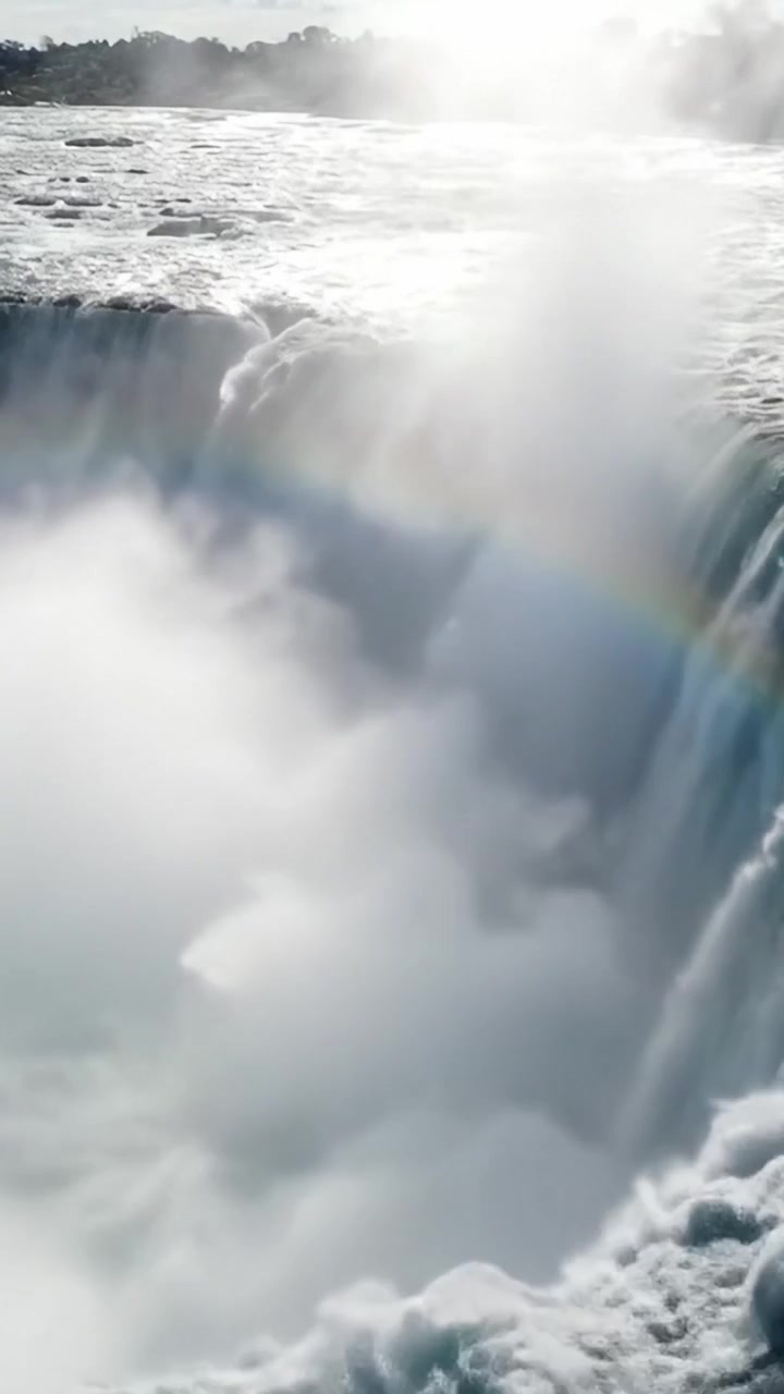 Maestosa cascata con nebbia e arcobaleno: accattivante meraviglia naturale avvolta tra le nuvole, che mostra la potenza e la bellezza dell'acqua che scende a cascata