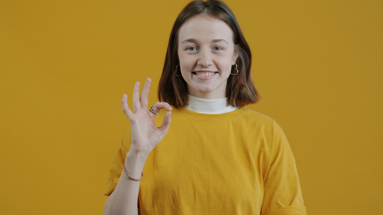 여성이 오케이 제스처를 하고 있습니다.