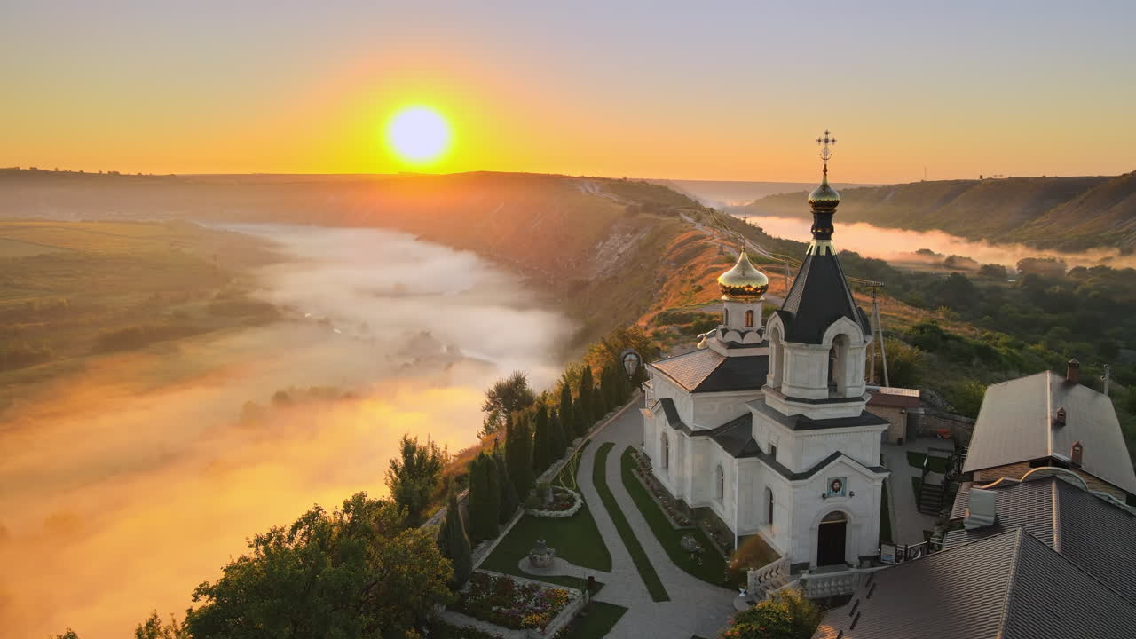 Aerial drone view of the Old Orhei at sunset. Valley with river and fog, monastery located on a hill in Moldova
